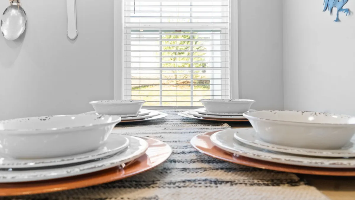 A warmly set dining table complete with elegant dinnerware and a window view that allows natural light to fill the space. The setup is perfect for family breakfasts, intimate dinners, or festive celebrations, exuding both style and comfort.