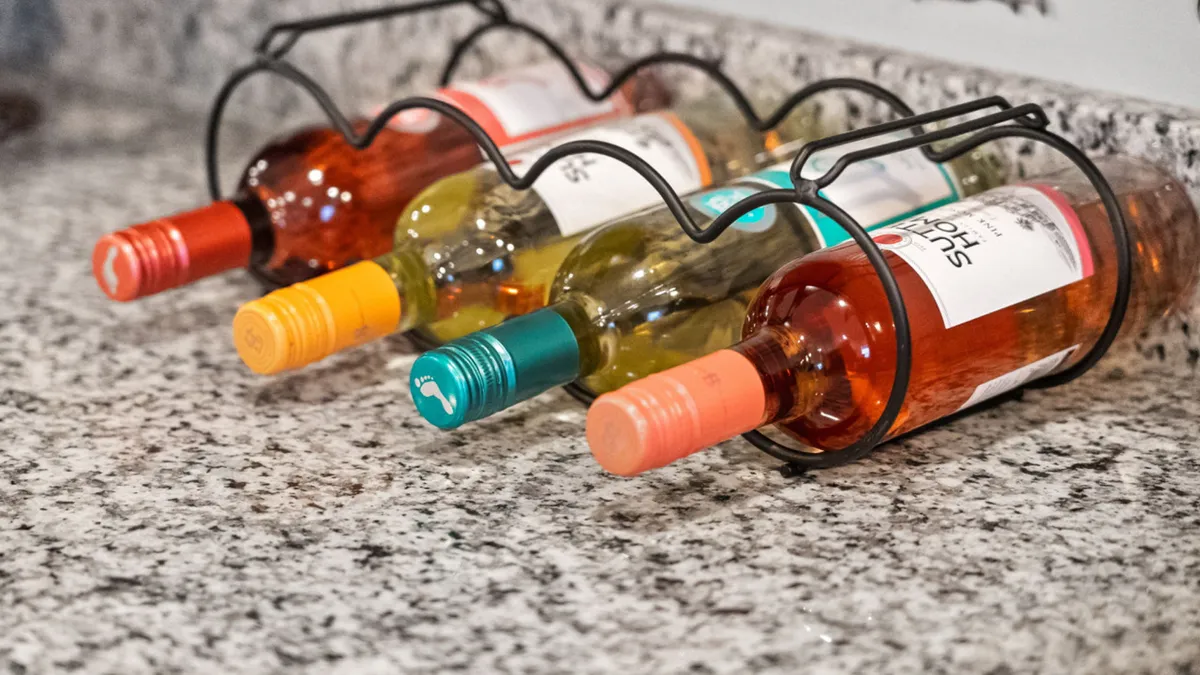 A rack of wine bottles sits atop a sleek granite countertop, creating an atmosphere perfect for wine tasting or quiet evenings. The setting is intimate and stylish, with elements that suggest a seamless flow between indoor elegance and outdoor leisure.